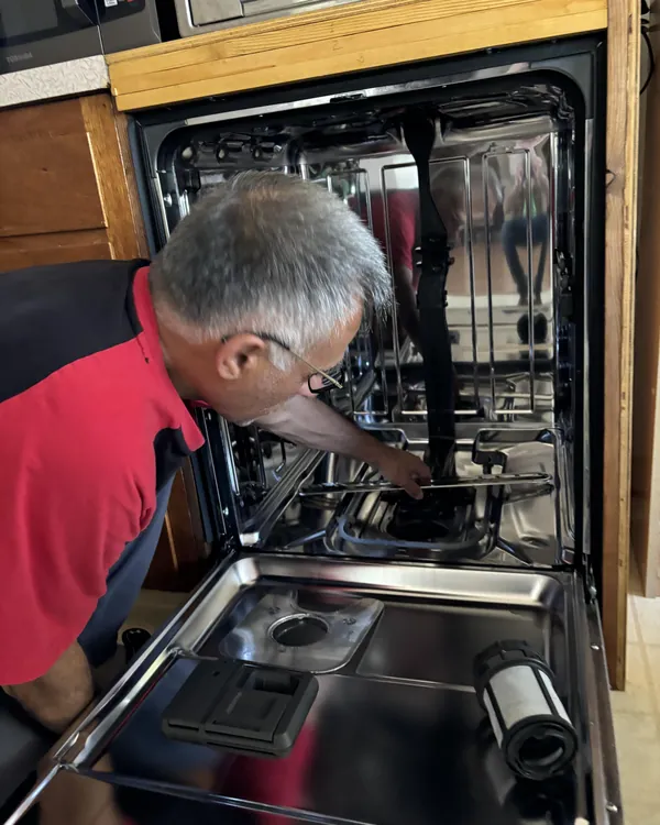 Yagub working inside an open dishwasher