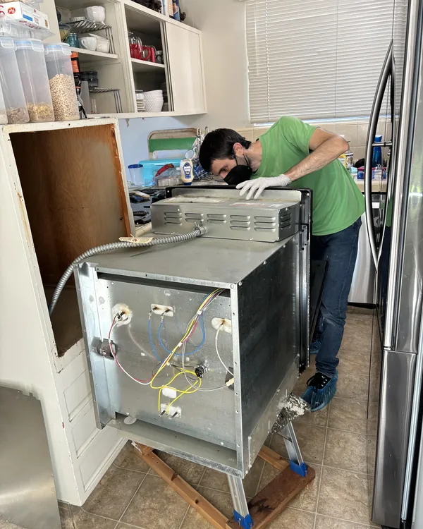 Jack pulling a dishwasher out for repair
